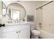 Bathroom featuring a modern vanity, round mirror, and a shower-tub combination at 3940 E Heather Ct, Gilbert, AZ 85234