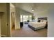 Serene main bedroom featuring a bay window, plush carpet, a fan, and an ensuite bathroom at 3940 E Heather Ct, Gilbert, AZ 85234