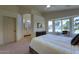 Spacious main bedroom featuring a bay window, plush carpet, a fan, and an ensuite bathroom at 3940 E Heather Ct, Gilbert, AZ 85234
