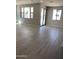 Bright living room with neutral walls, wood-look tile flooring, and sliding glass doors at 4924 W Brown St, Glendale, AZ 85302
