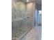 Modern shower with marble tile and glass enclosure, complemented by stylish floor tiles at 4924 W Brown St, Glendale, AZ 85302