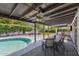 Inviting covered backyard patio with ceiling fan, outdoor dining, pool, built-in grill, and seating area at 5101 E Paradise Dr, Scottsdale, AZ 85254