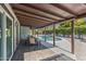Back patio with outdoor dining, ceiling fan, and views of the sparkling pool and lush landscaping at 5101 E Paradise Dr, Scottsdale, AZ 85254