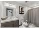This bathroom features a vanity with a decorative mirror and shower with gray curtain at 5101 E Paradise Dr, Scottsdale, AZ 85254