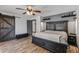 A spacious main bedroom with wood-look floors, rustic barn door, and a dark wood bed frame at 5101 E Paradise Dr, Scottsdale, AZ 85254