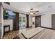 Main bedroom featuring wood-look floors, rustic barn door, a ceiling fan, and doors to the pool area at 5101 E Paradise Dr, Scottsdale, AZ 85254