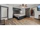 A spacious main bedroom features wood-look floors, rustic barn door and a king bed frame at 5101 E Paradise Dr, Scottsdale, AZ 85254