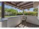 Stylish outdoor bar area with seating, granite countertops, and pergola, creating an inviting space at 5101 E Paradise Dr, Scottsdale, AZ 85254