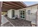 Covered patio with lounge chair, brick floors, french doors to pool, and white brick exterior at 5101 E Paradise Dr, Scottsdale, AZ 85254