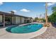 Backyard oasis featuring a pristine pool, covered patio, and desert landscaping at 5101 E Paradise Dr, Scottsdale, AZ 85254