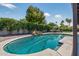 A backyard pool with a rock waterfall feature is surrounded by lush green trees and tropical landscaping at 5101 E Paradise Dr, Scottsdale, AZ 85254
