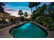 Backyard pool with a relaxing lounge area surrounded by lush landscaping and palm trees in a resort like setting at sunset at 538 W Las Palmaritas Dr, Phoenix, AZ 85021