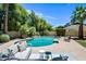 Backyard pool with a relaxing lounge area with comfortable seating, surrounded by manicured landscaping and mature trees at 538 W Las Palmaritas Dr, Phoenix, AZ 85021