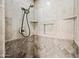 Elegant shower with tile surround, built-in shelves, and modern shower head at 538 W Las Palmaritas Dr, Phoenix, AZ 85021