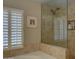 Bright bathroom featuring a shower with glass door, tile walls, and a bathtub at 5431 E Piping Rock Rd, Scottsdale, AZ 85254