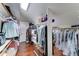 Bright walk-in closet with custom shelving, skylight, hardwood floors, and ample storage space at 5431 E Piping Rock Rd, Scottsdale, AZ 85254