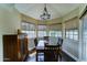 Dining area featuring a dark wood table, bay windows, and a statement chandelier at 5431 E Piping Rock Rd, Scottsdale, AZ 85254