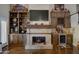 Spacious living area features a stone fireplace with custom built-ins, a large flatscreen TV, and hardwood floors at 5431 E Piping Rock Rd, Scottsdale, AZ 85254