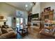 Spacious living area features high ceilings, a stone fireplace, a large flatscreen TV, and hardwood floors at 5431 E Piping Rock Rd, Scottsdale, AZ 85254