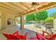 Relaxing covered patio with travertine tile, ceiling fan, outdoor furniture, and pool views at 5431 E Piping Rock Rd, Scottsdale, AZ 85254