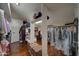 Spacious walk-in closet with wood floor and ample storage including shelving, hanging rods, and baskets at 5431 E Piping Rock Rd, Scottsdale, AZ 85254