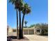 Beige stucco home featuring a two-car garage, palm trees, desert landscaping, and a concrete driveway at 632 W Fordham Dr, Tempe, AZ 85283