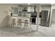 Kitchen featuring stainless steel appliances, white cabinets, tiled backsplash, and bar seating at 632 W Fordham Dr, Tempe, AZ 85283