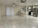 Spacious living room featuring tile floors, two ceiling fans, bar seating, and kitchen access at 632 W Fordham Dr, Tempe, AZ 85283