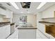 Well-lit kitchen featuring an island cooktop, tiled floors, white cabinets, and sliding glass doors leading to the backyard at 8411 E Via De Jardin --, Scottsdale, AZ 85258