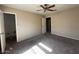 Spacious bedroom includes ceiling fan, carpet flooring, two doors, and neutral wall paint at 990 E Desert Rose Trl, San Tan Valley, AZ 85143