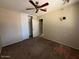 Bedroom featuring a ceiling fan and large closet, in need of repair at 990 E Desert Rose Trl, San Tan Valley, AZ 85143