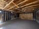 Spacious garage with unfinished walls and exposed ceiling beams, in need of repair at 990 E Desert Rose Trl, San Tan Valley, AZ 85143