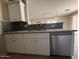 Bright kitchen showcasing a stainless steel dishwasher and sink with granite countertops and backsplash at 990 E Desert Rose Trl, San Tan Valley, AZ 85143