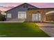 A backyard features a covered patio, green lawn, and access to the home through sliding glass doors at 1405 E Chicago Cir, Chandler, AZ 85225