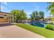 Outdoor living at its finest with a covered patio, turf lawn, and serene waterfront views at 1405 E Chicago Cir, Chandler, AZ 85225