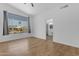 Bright bedroom featuring wood-look floors, large window with neighborhood views, and bathroom access at 1405 E Chicago Cir, Chandler, AZ 85225