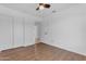 Bright bedroom featuring wood floors, a ceiling fan, and closet with sliding doors at 1405 E Chicago Cir, Chandler, AZ 85225