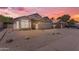 Charming single-story home featuring a two-car garage, desert landscaping, and a picturesque sunset sky at 1405 E Chicago Cir, Chandler, AZ 85225
