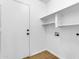 Laundry room with wood floors, shelves, washer and dryer hookups, and an exterior door at 1405 E Chicago Cir, Chandler, AZ 85225