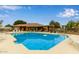 Community pool with lounge chairs, tables and chairs with umbrellas in a well maintained setting at 1405 E Chicago Cir, Chandler, AZ 85225