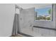 A remodeled shower features marble-look tile, a shower bench, and a rain shower head at 1405 E Chicago Cir, Chandler, AZ 85225