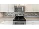Modern kitchen featuring stainless steel appliances, stylish backsplash, and white cabinetry at 1430 N Ashland --, Mesa, AZ 85203