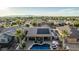 A high aerial view captures a backyard oasis with a pool, covered patio, and beautiful mountain views at 16077 W Anasazi St, Goodyear, AZ 85338