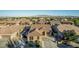 Expansive aerial view showcases a home with a tile roof and desert landscaping in a well-maintained community at 16077 W Anasazi St, Goodyear, AZ 85338