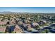 Community aerial view reveals picturesque homes, lush trees, and expansive desert landscape and mountain backdrop at 16077 W Anasazi St, Goodyear, AZ 85338