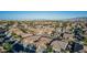 The aerial view showcases a desert community with well-maintained houses, solar panels, and green trees at 16077 W Anasazi St, Goodyear, AZ 85338