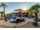 This serene backyard features a pool with a waterfall, covered seating area, and lush landscaping at 16077 W Anasazi St, Goodyear, AZ 85338