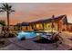 Stunning backyard with a sparkling pool, a tranquil waterfall feature, and comfortable lounge seating at 16077 W Anasazi St, Goodyear, AZ 85338