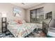 This bedroom features a unique ocean-themed comforter and beach themed artwork, all illuminated by natural light at 16077 W Anasazi St, Goodyear, AZ 85338