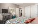 This bedroom is furnished with a unique ocean-themed comforter, a desk, and a closet with sliding doors at 16077 W Anasazi St, Goodyear, AZ 85338
